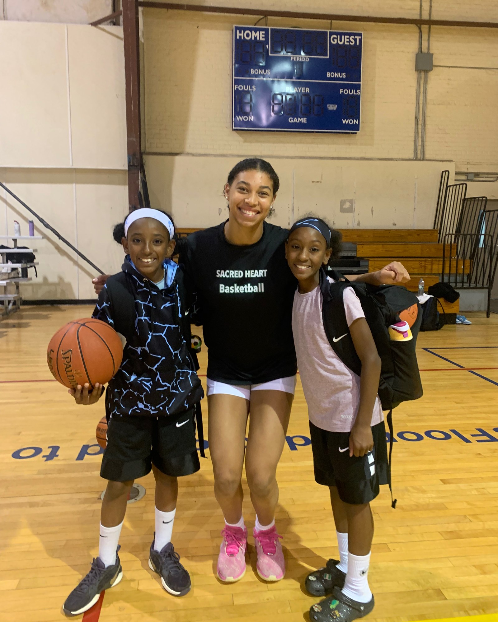 Eva Wilkerson, who signed to play Division I basketball at Towson, with two younger Lace Up players in the gym