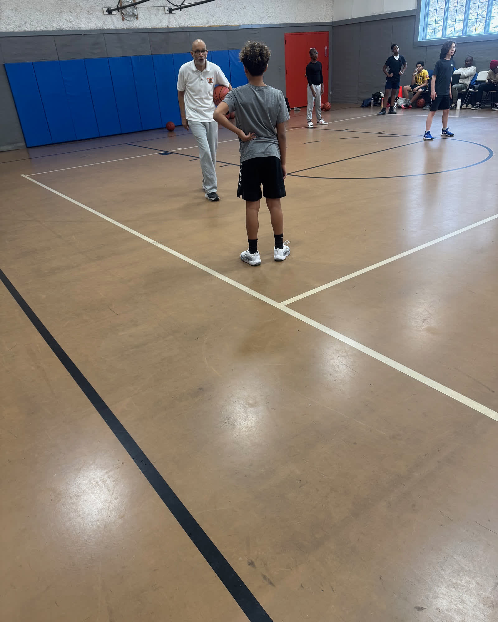 Lace Up coach running a drill with a player on the court