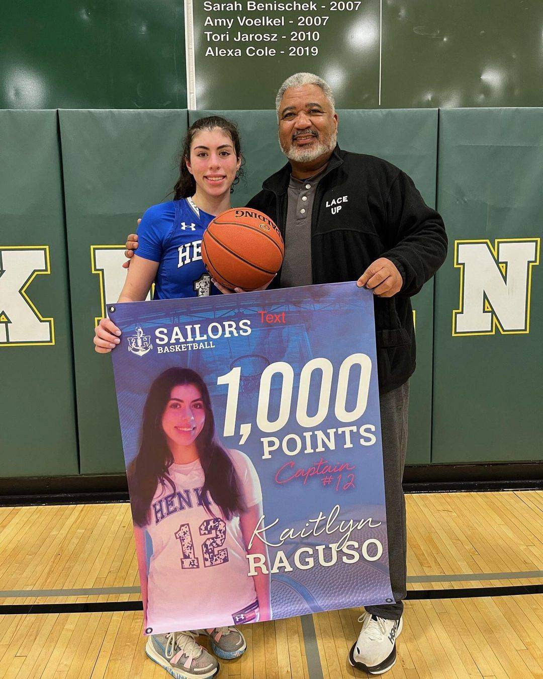 Coach Robinson with a Lace Up player holding her 1,000-point banner