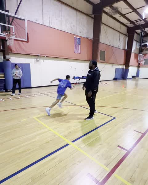 Player driving toward a coach during a gym drill