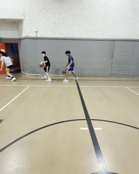 Two players dribbling side by side during a drill